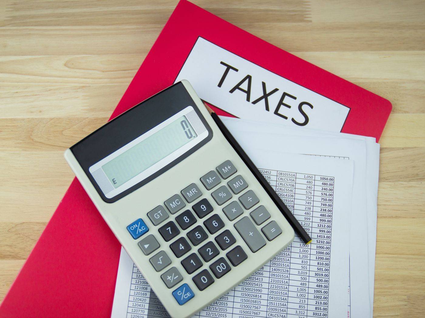 Tax documents and a calculator on a desk
